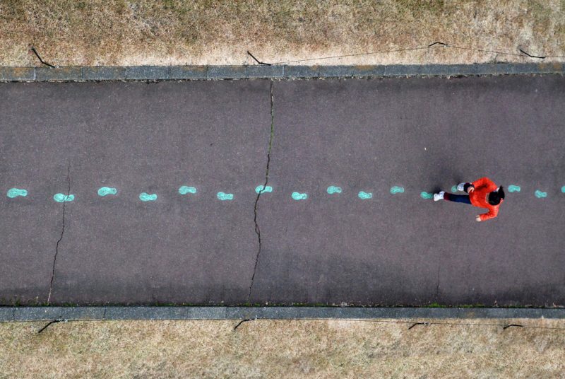 A women stepping on a colorful path of footsteps